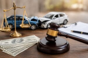 lawyer desk with items representing who pays after a car accident lawsuit
