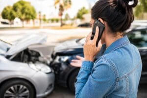 woman on phone after car accident asking should I tell my insurance company about an accident